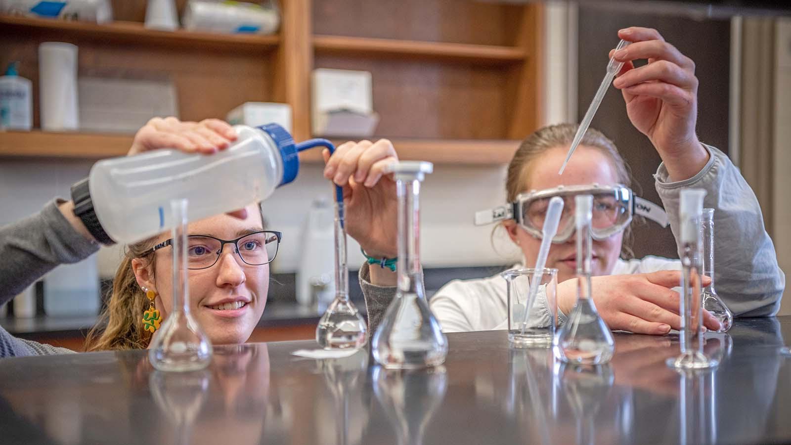 Two SURVE students adding solutions into beakers